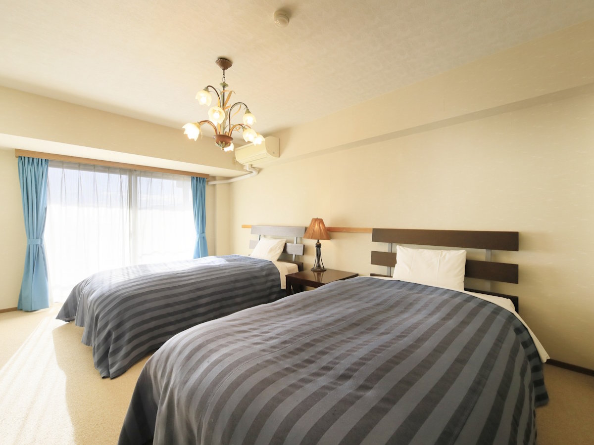 【グランドルーム一例】セミダブルベッド2台の寝室。